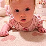 baby, infant, face, eyes, pink_clothing, floral_pattern, blanket, heart_pattern, nursery, soft_lighting, curious_expression, crawling, child, indoors, cute, portrait, closeup, young_child, adorable, baby_girl