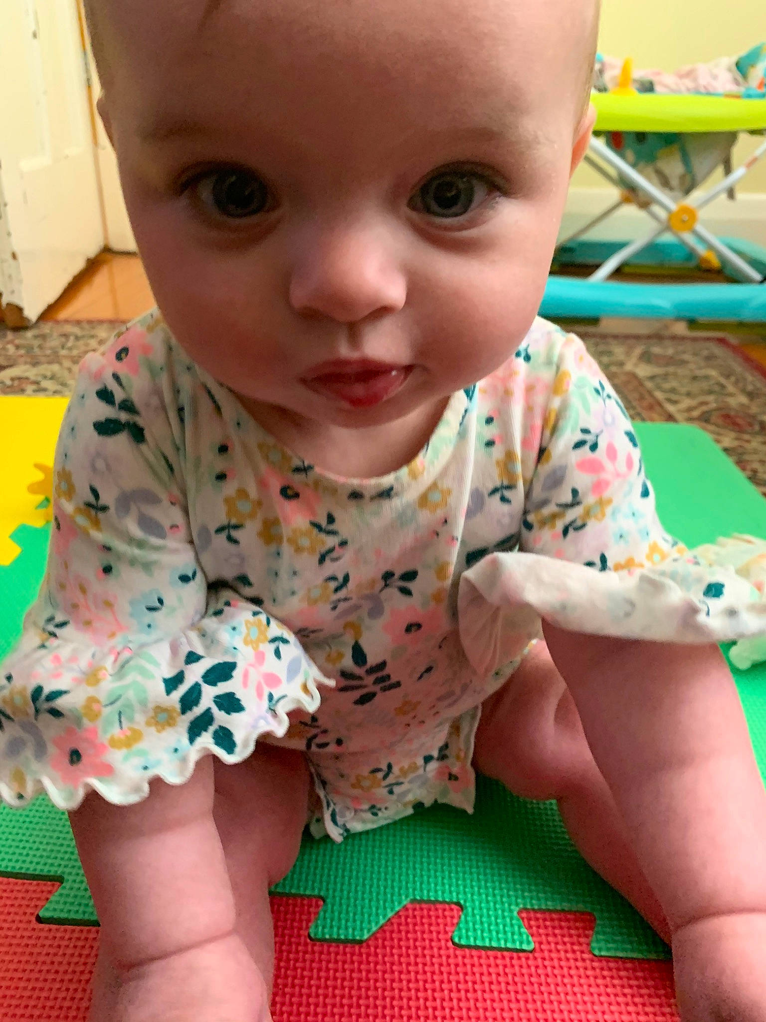Edith is registered to the contest to win money with this photo: baby, baby_toddler_clothing, cheek, child, dress, face, head, pattern, person, play, sitting, skin, sleeve, toddler, tummy_time