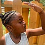 braided_hair, casual_clothing, child, daylight, earrings, expression, fence, girl, nature, outdoor, person, portrait, profile, shade, side_view, skin, summer, sunlight, tank_top, young