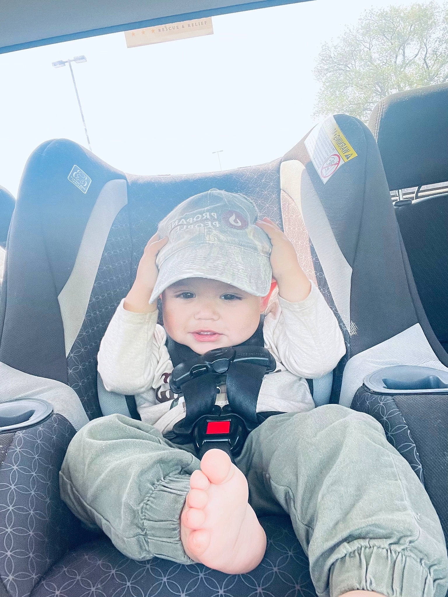 Jesus is registered to the contest to win money with this photo: automotive_design, automotive_exterior, baseball_cap, car_seat, car_seat_cover, comfort, cool, electric_blue, fun, hat, head_restraint, headwear, lap, leg, motor_vehicle, person, shoe, sneakers, toddler, travel