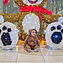 baby, brown, child, costume, curious, cute, decoration, face, festive, floor, holiday, indoor, lights, plush, red_scarf, sitting, smile, teddy_bear, toy, white_lights
