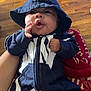 Zakari is registered to the contest to win money with this photo: baby, hoodie, child, infant, hand, face, expression, clothing, person, sitting, blanket, floor, wooden_floor, indoor, zipper, hood, cute, young_child, casual_wear, holding