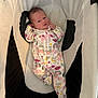 baby, newborn, infant, onesie, unicorn_pattern, rainbow_pattern, baby_seat, cushion, soft_fabric, sleepwear, cute, small, child, indoor, portrait, baby_clothing, resting, lying_down, pink, white