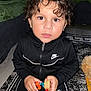 Elijah is registered to the contest to win money with this photo: child, curly_hair, black_clothing, nike, toy, carpet, indoor, kneeling, brown_eyes, person, home, floor, patterned_rug, casual_wear, cute, young_child, playing, curious, sleeves, zipper