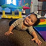 bow, carpet, chair, child, clothing, colorful, crawling, curly_hair, cute, face, furniture, happy, indoor, person, playroom, rainbow_mat, smile, toddler, toy, window