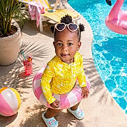 Ra'Siyah joined the competition — help win amazing prizes! toddler, child, poolside, swimsuit, inflatable_ring, heart_shaped_sunglasses, beach_ball, flamingo_float, summer, sunny, outdoor, potted_plant, lounge_chair, drink, shadow, concrete, smiling, playful, water, footwear