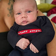 Owen participe au concours pour gagner de l'argent avec cette photo : baby, infant, face, person, clothing, arm, tattoo, indoor, portrait, cute, newborn, holding, looking, expression, skin, hand, sleeve, red, navy, closeup