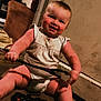 baby, child, smiling, indoor, carpet, game_controller, toy, person, couch, door, wall, clothing, foot, hand, furniture, living_room, playing, happy, sitting, cute