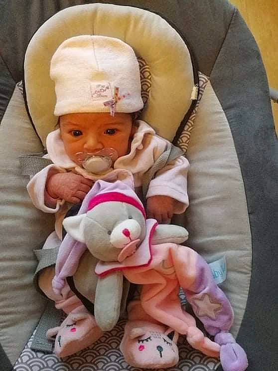 Naya participe au concours pour gagner de l'argent avec cette photo : arm, baby, baby_carriage, baby_products, baby_sleeping, baby_toddler_clothing, cheek, child, comfort, finger, hand, headwear, lap, leg, linens, person, pink, product, sitting, skin