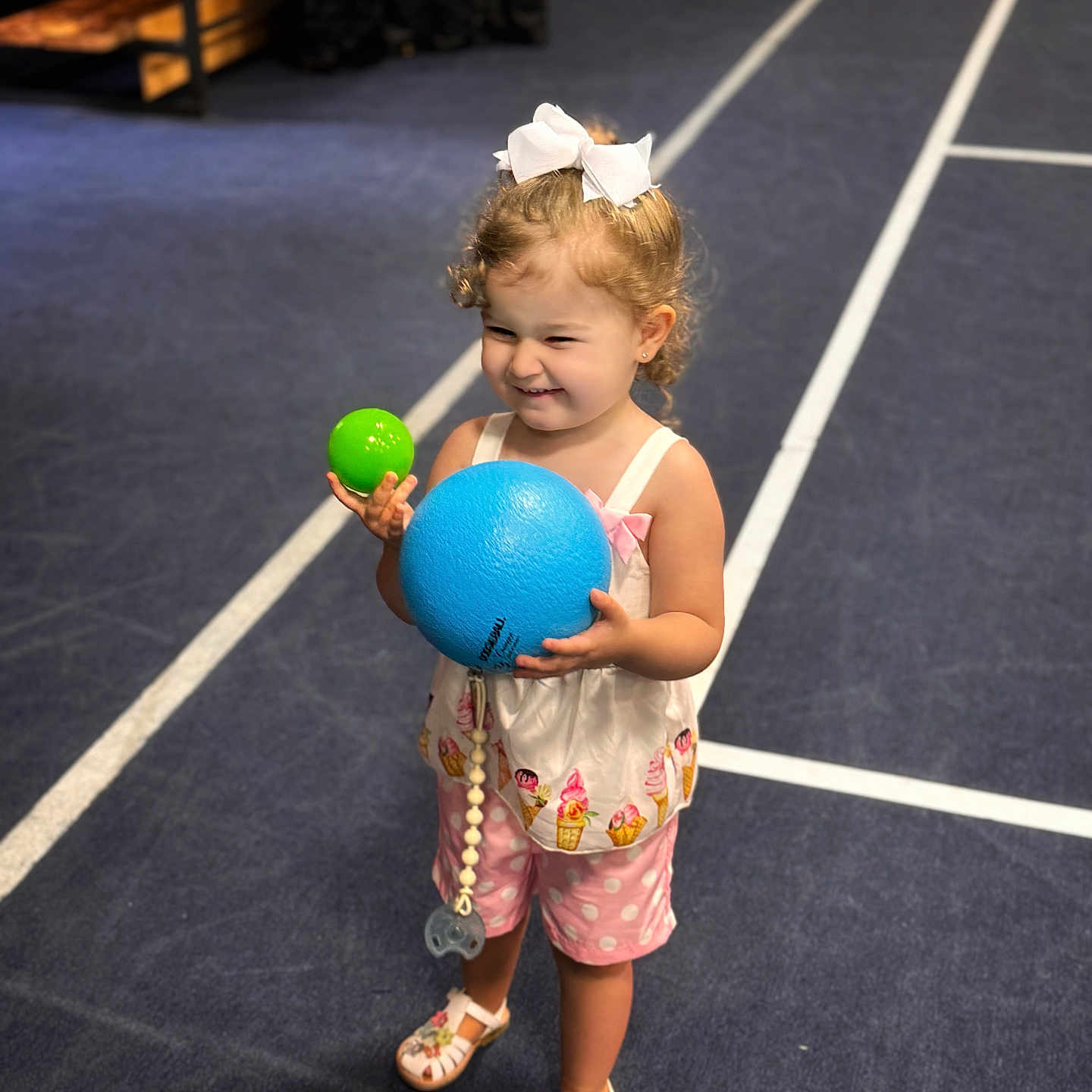 Ayla is registered to the contest to win money with this photo: adult, astronomy, ball, bride, child, clothing, face, female, football, footwear, girl, head, outerspace, person, shoe, shorts, soccer, soccerball, sphere, sport