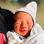 newborn, baby, smiling, closed_eyes, hat, blanket, wrapped, soft_light, close_up, infant, peaceful, cute, sleeping, portrait, skin, human, headwear, comfort, warm, indoors