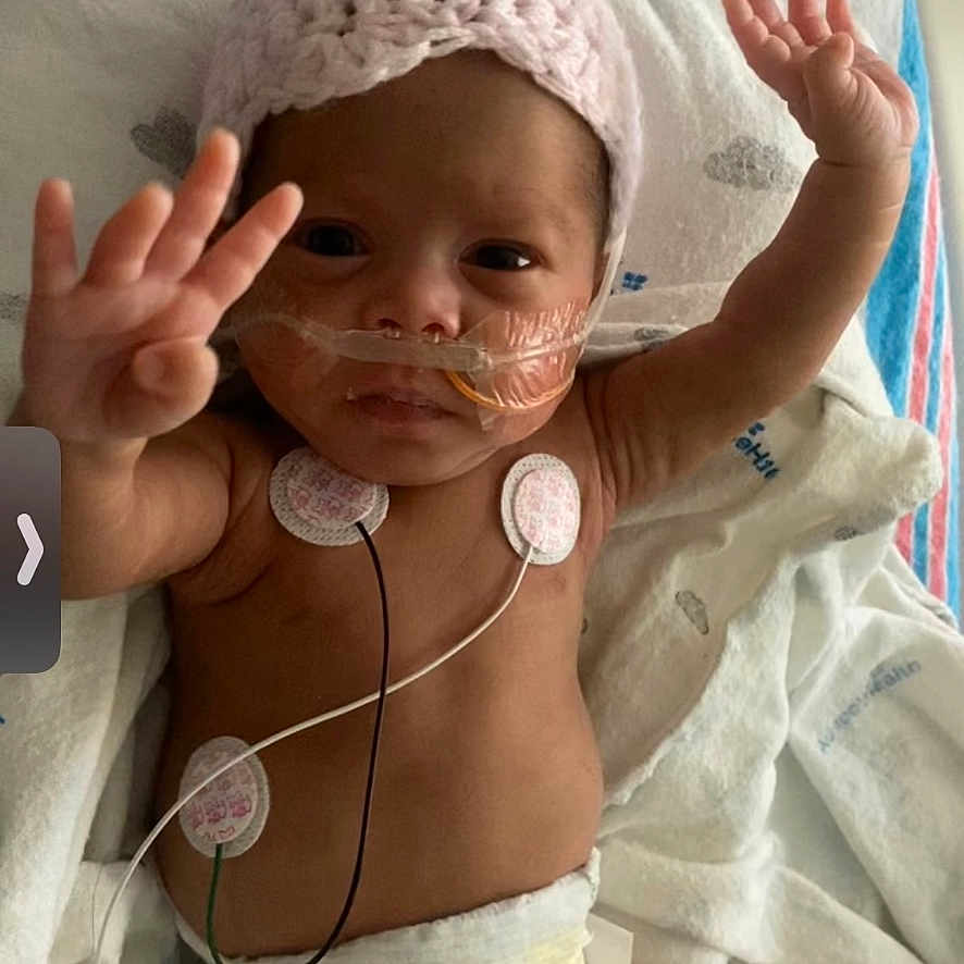 Selena joined the competition — help win amazing prizes! architecture, baby, bodypart, bonnet, building, cap, clothing, diaper, face, finger, furniture, glove, hand, hat, head, hospital, newborn, person, photography, portrait