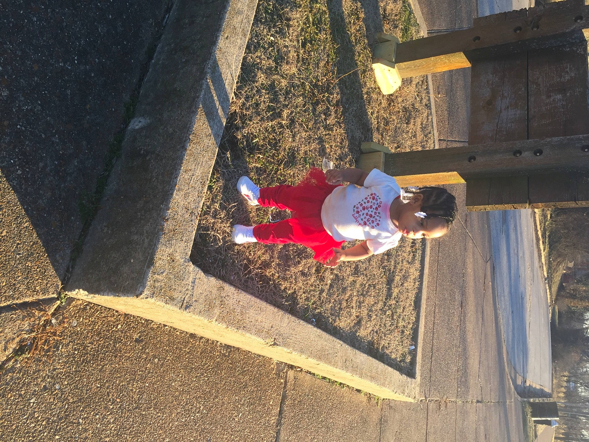 Armoni is registered to the contest to win money with this photo: asphalt, carmine, composite_material, concrete, electric_blue, hat, leisure, pedestrian, person, public_space, road_surface, shadow, sidewalk, soil, tar, tints_and_shades, toddler, walking_shoe, wall, wood