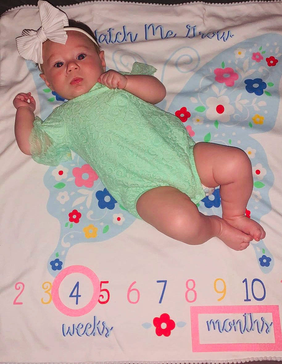 Brynn is registered to the contest to win money with this photo: art, baby, baby_products, baby_toddler_clothing, child, circle, comfort, face, finger, font, happy, headwear, linens, magenta, pattern, person, pink, play, sleeve, t_shirt