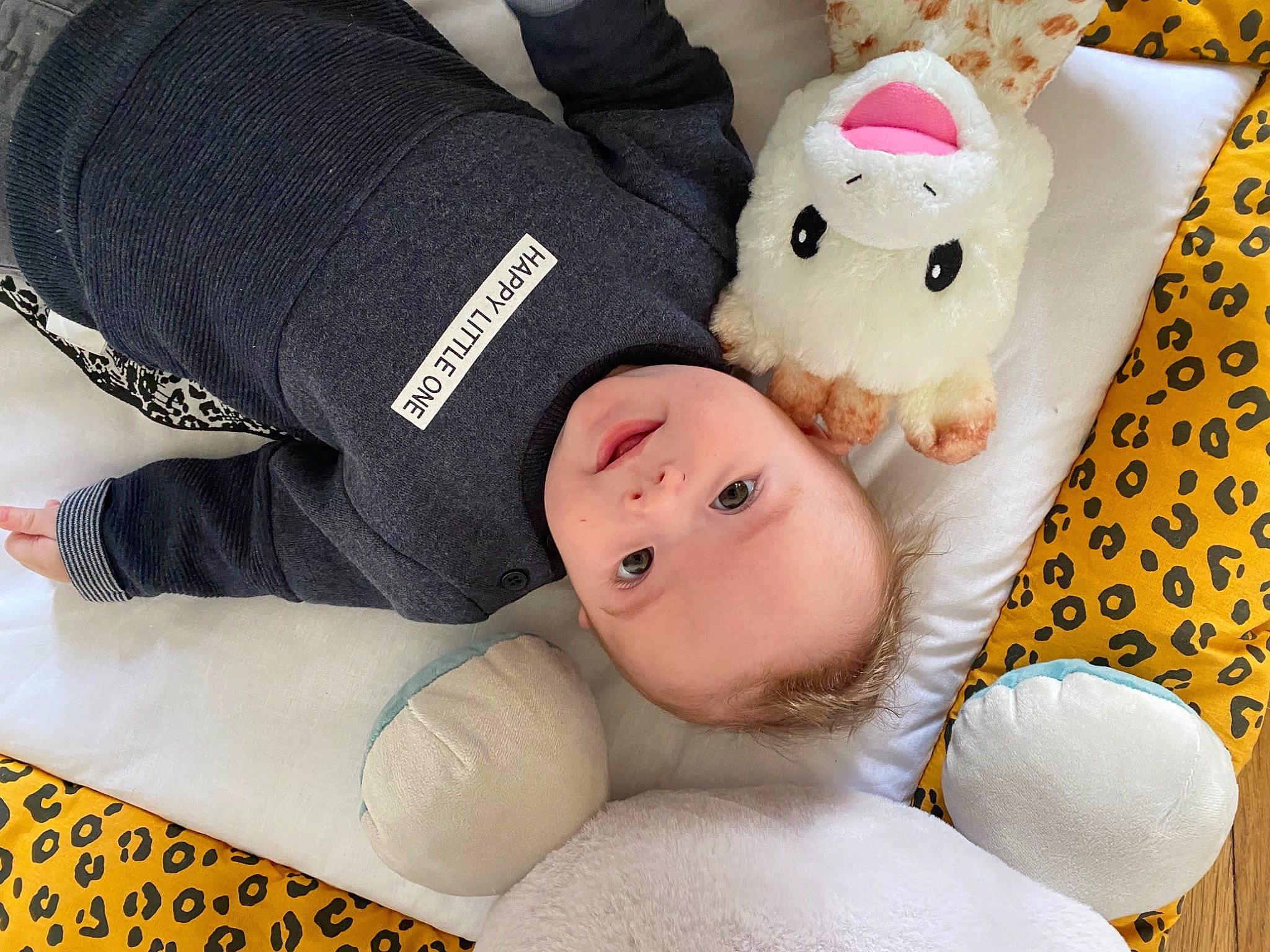 Tiago a rejoint le concours — aidez-le/la à gagner de superbes lots ! baby, baby_products, baby_sleeping, baby_toddler_clothing, baby_toys, bedding, child, comfort, happy, linens, person, plush, room, sleeve, smile, stuffed_toy, teddy_bear, toddler, toy, white