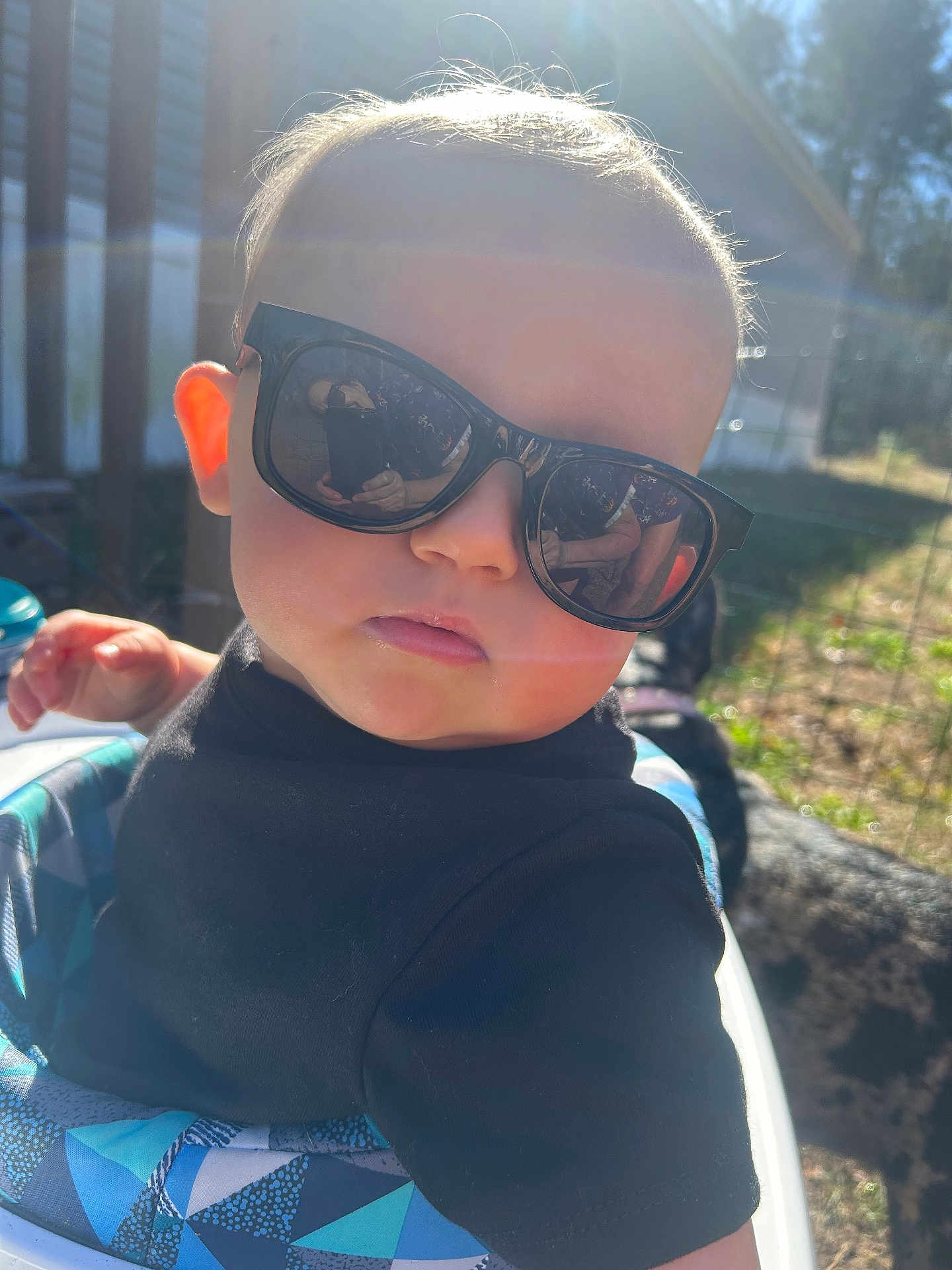 Karson joined the competition — help win amazing prizes! baby, toddler, child, sunglasses, reflection, sunflare, outdoor, backyard, baby_seat, black_shirt, chubby_cheeks, portrait, person, hair, cool_expression, dog, sunglasses_reflection, sunlight, hand, cute
