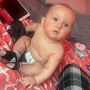Karson joined the competition — help win amazing prizes! baby, infant, diaper, blanket, bed, pillow, tablet, baby_wipe, socks, plaid_pants, rosy_cheeks, sitting, bare_torso, chubby, curious_gaze, face, eyes, indoor, soft_texture, bedding_pattern