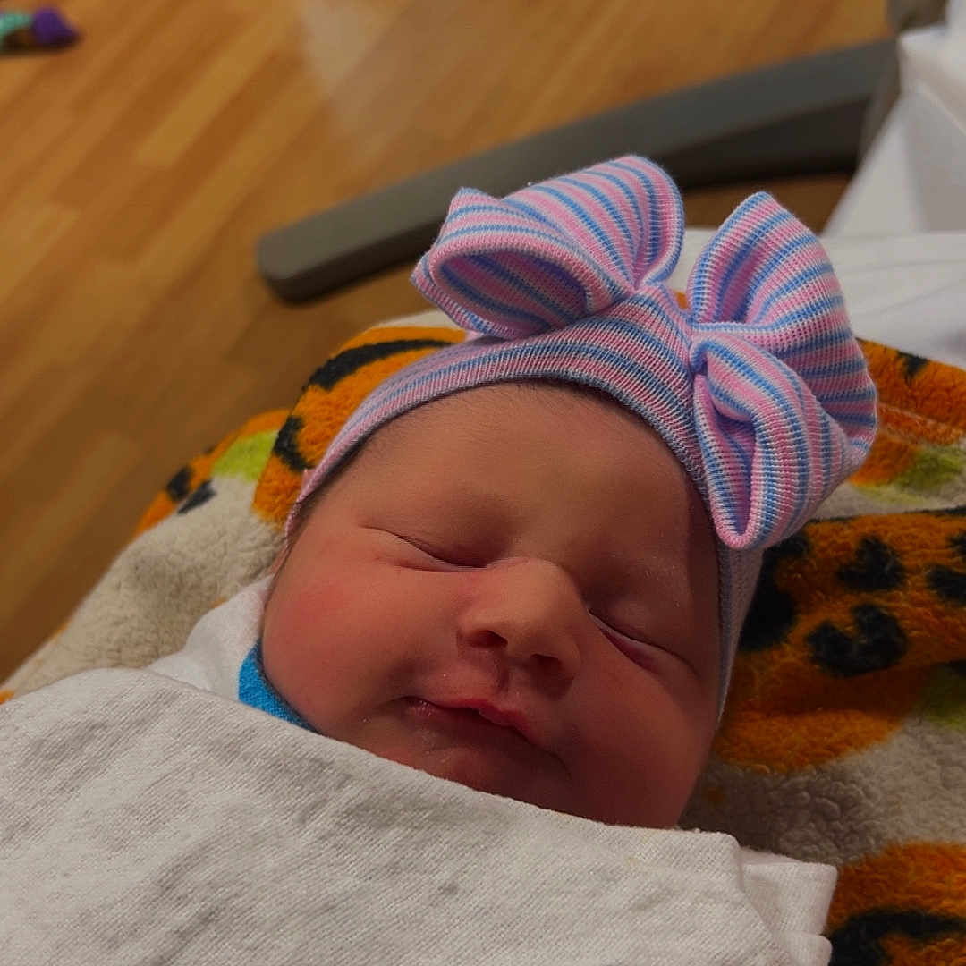 Maisly is registered to the contest to win money with this photo: baby, bed, blanket, bonnet, cap, clothing, couch, face, furniture, hardwood, hat, head, newborn, person, photography, portrait, quilt, sleeping, towel, wood