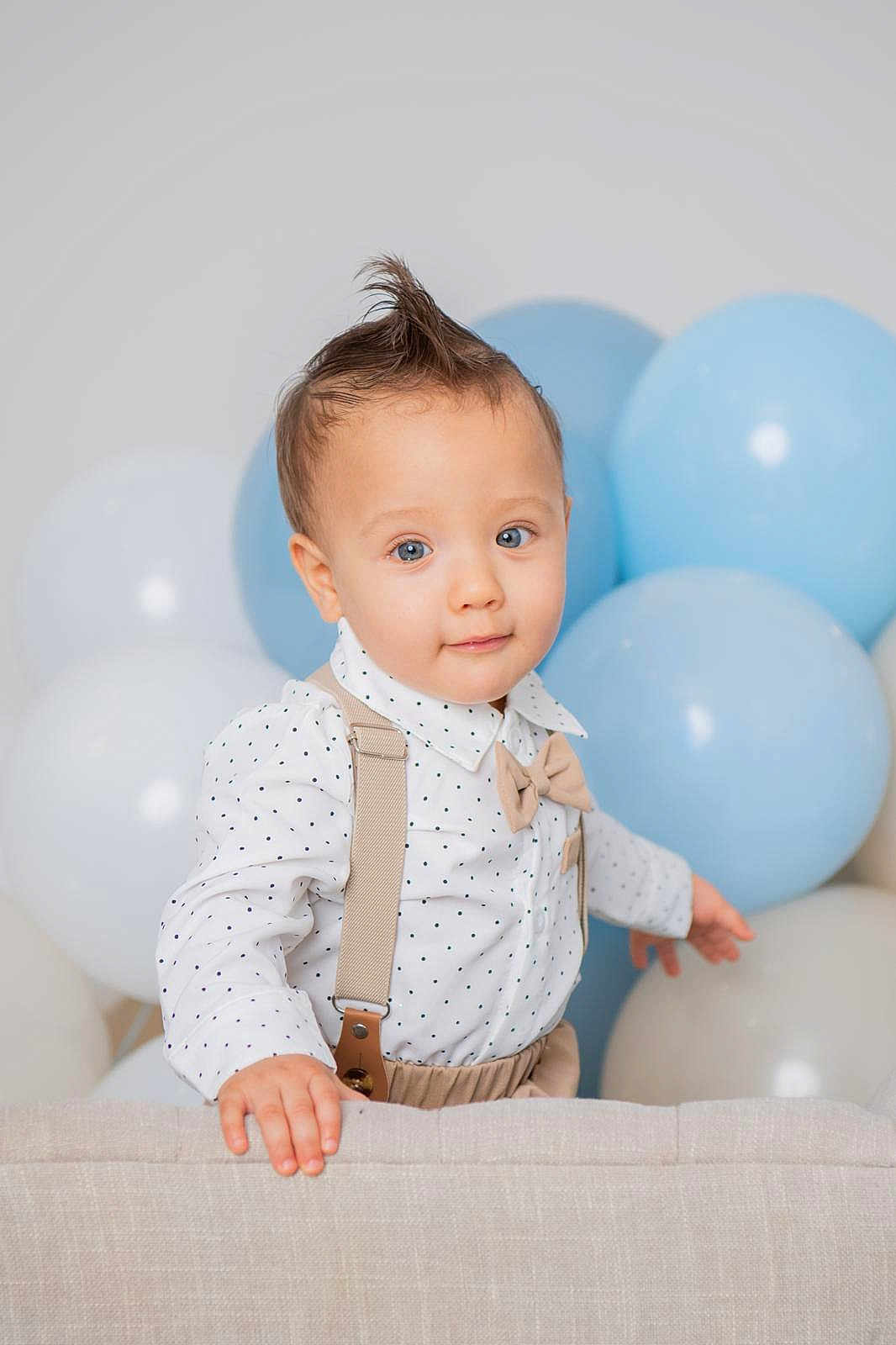 Justin joined the competition — help win amazing prizes! toddler, child, baby, blue_eyes, mohawk, polka_dot, shirt, suspenders, bow_tie, balloons, blue, white, couch, hand, curious, portrait, indoor, cute, fashion, smile