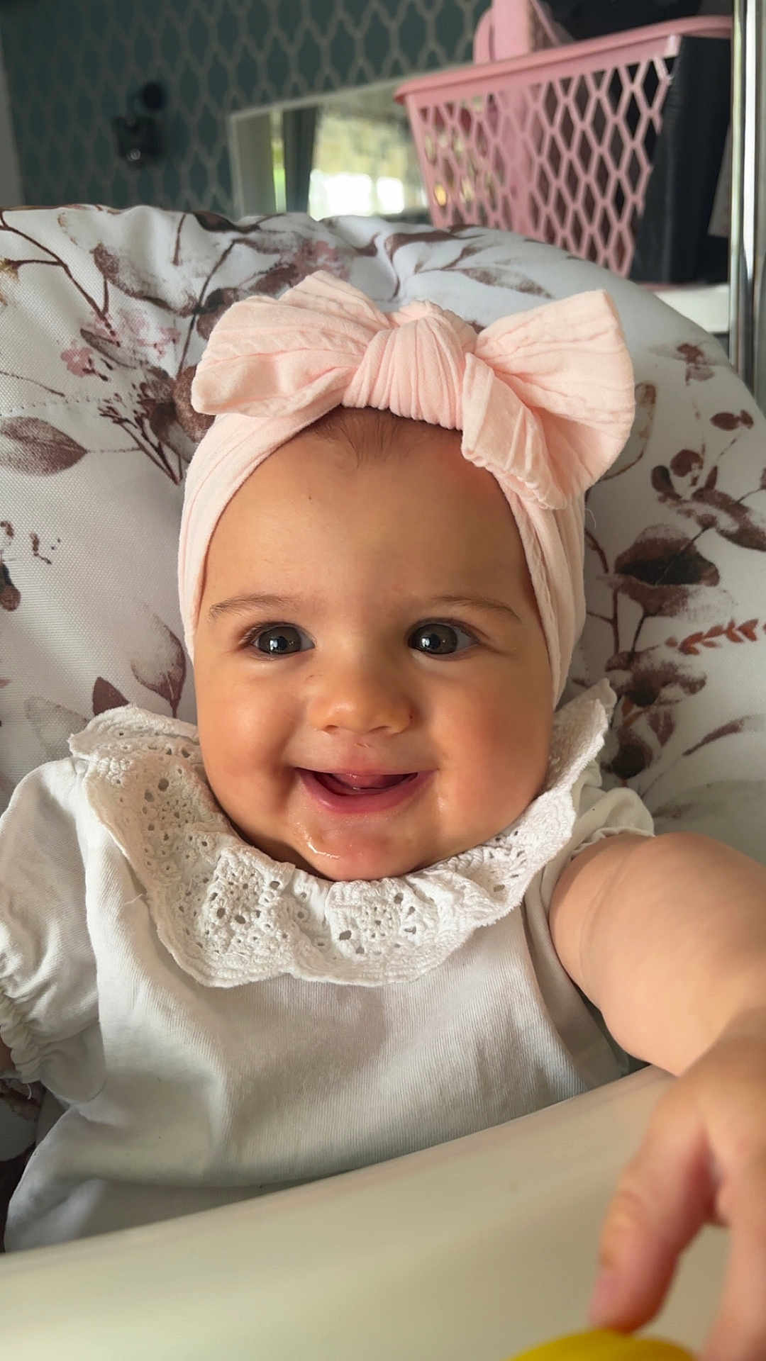 Romane participe au concours pour gagner de l'argent avec cette photo : baby, child, smile, headband, pink, white_clothing, lace, face, arm, hand, indoor, cushion, floral_pattern, highchair, happy, infant, portrait, cute, person, closeup
