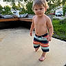 toddler, child, barefoot, shorts, outdoor, patio, concrete, trees, greenery, bench, cushions, house, car, daylight, summer, person, cute, young, walking, casual