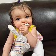 Echo is registered to the contest to win money with this photo: baby, child, toddler, blue_eyes, pony_tail, stuffed_toy, bunny, couch, yellow_clothing, white_tights, indoor, cute, playing, chewing, soft_toy, happy, portrait, infant, seated, young_child