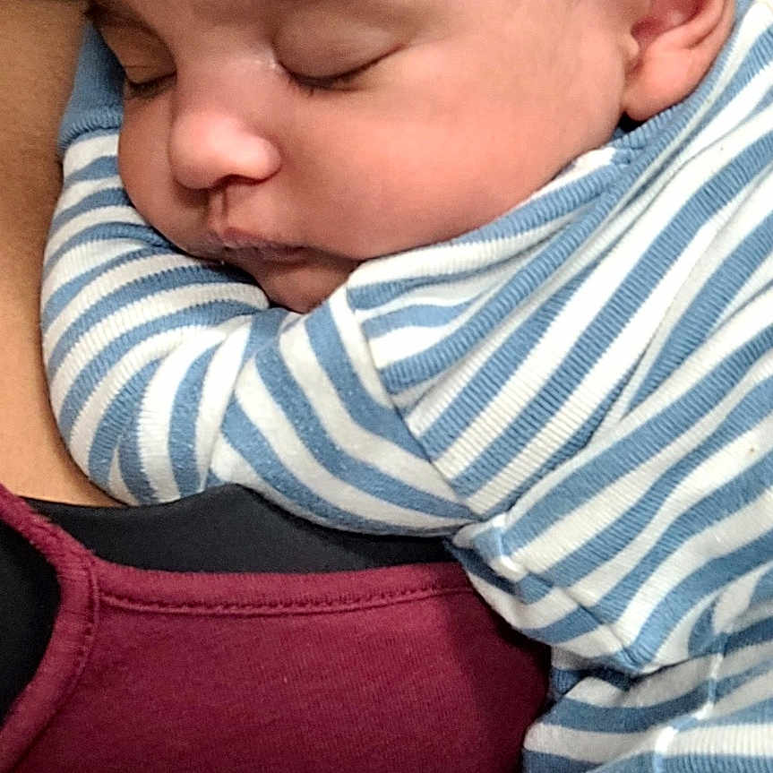 Brie joined the competition — help win amazing prizes! baby, sleeping, striped_clothing, onesie, infant, child, closeup, face, portrait, person, comfort, cuddle, snuggle, adult, maroon_top, skin, hair, peaceful, rest, indoor