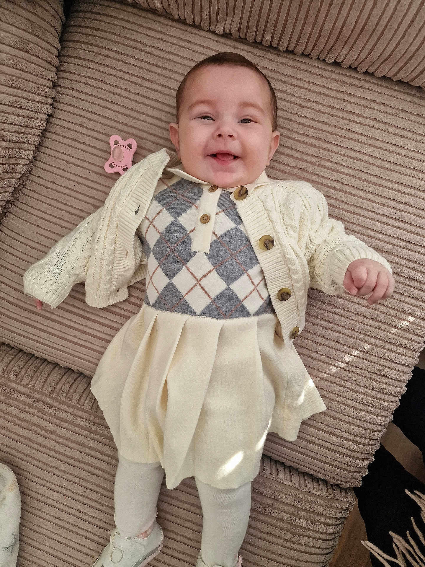 Aaliyah joined the competition — help win amazing prizes! baby, smiling, infant, couch, cream_clothing, argyle_pattern, cardigan, pleated_skirt, pacifier, happy, indoors, tights, shoes, cute, child, portrait, cozy, textured_fabric, relaxed, laying_down
