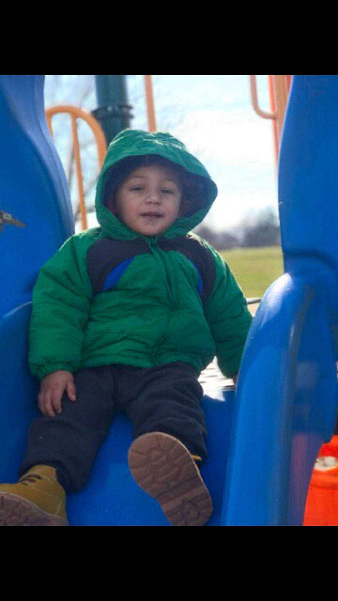 Lashaun is registered to the contest to win money with this photo: baby, baseball_cap, blue, cap, child, city, electric_blue, fun, grass, happy, headwear, hoodie, leisure, outdoor_play_equipment, person, personal_protective_equipment, play, playground, recreation, sitting