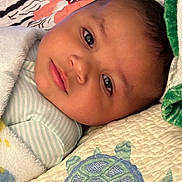 Blake joined the competition — help win amazing prizes! baby, blanket, quilt, turtle, face, infant, child, lying_down, soft_texture, striped_clothing, bed, comfort, cute, portrait, sleepwear, head, peaceful, indoors, closeup, resting