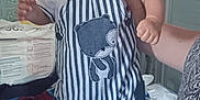 Valentin a rejoint le concours — aidez-le/la à gagner de superbes lots ! adult, baby, bear_patch, bed, blanket, blue, child, furniture, hand, holding, indoor, patterned_blanket, person, red, smiling, socks, standing, striped_overalls, tiled_wall, white_shirt