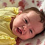 baby, infant, smiling, face, yellow_clothing, blanket, soft_texture, portrait, cute, child, happy, lying_down, close_up, skin, head, eyes, mouth, newborn, cozy, indoors