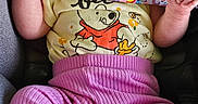 Addison joined the competition — help win amazing prizes! baby, infant, car_seat, pacifier, clothing, pink_pants, yellow_shirt, winnie_the_pooh, cute, child, small_feet, sitting, indoors, safety_harness, person, portrait, head, face, hand, foot