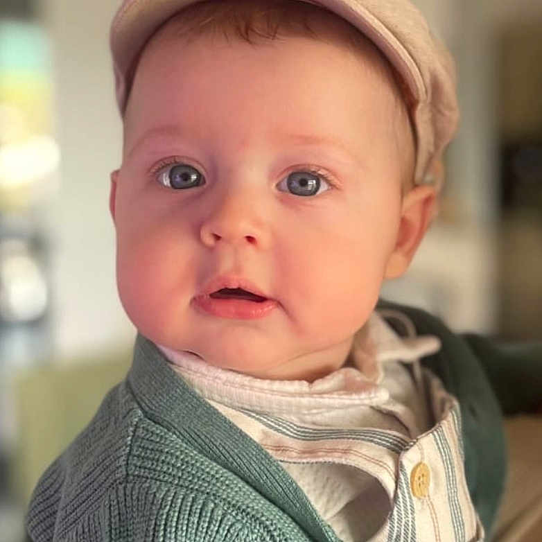 Djivan a rejoint le concours — aidez-le/la à gagner de superbes lots ! baby, child, cap, cardigan, clothing, cute, face, indoor, infant, looking, portrait, sitting, soft_light, striped_shirt, young_child, hand, person, expression, curious, warm