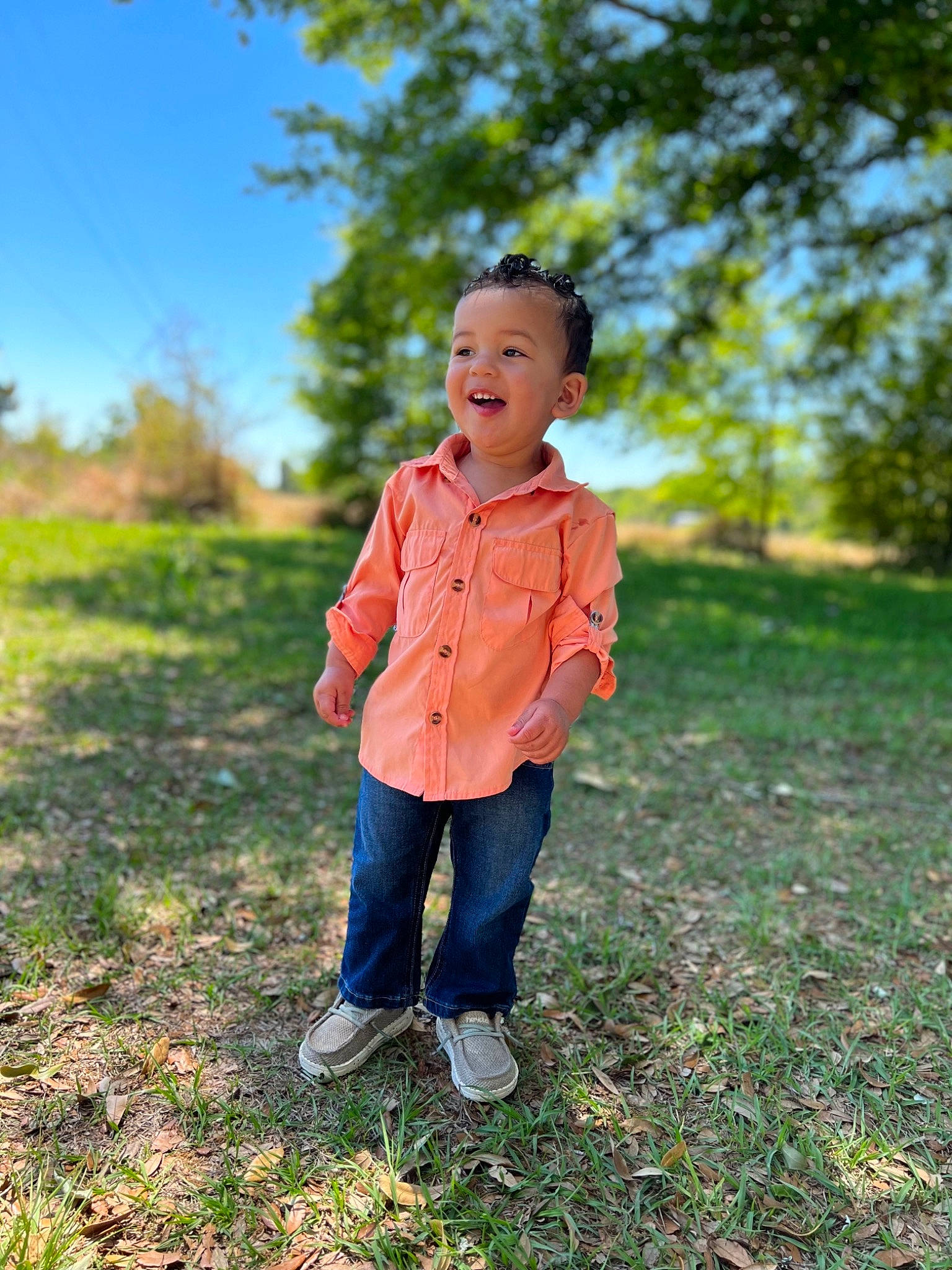 Korbyn joined the competition — help win amazing prizes! clothing, denim, forest, gesture, grass, grassland, happy, jeans, landscape, leisure, meadow, people_in_nature, person, plant, sky, smile, soil, sunlight, toddler, tree