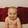Wyatt joined the competition — help win amazing prizes! baby, infant, child, smiling, sitting, portrait, bed, bedroom, red_pillows, blanket, diaper, bare_arms, bare_feet, happy, face, indoor, home, cozy, adorable, photograph