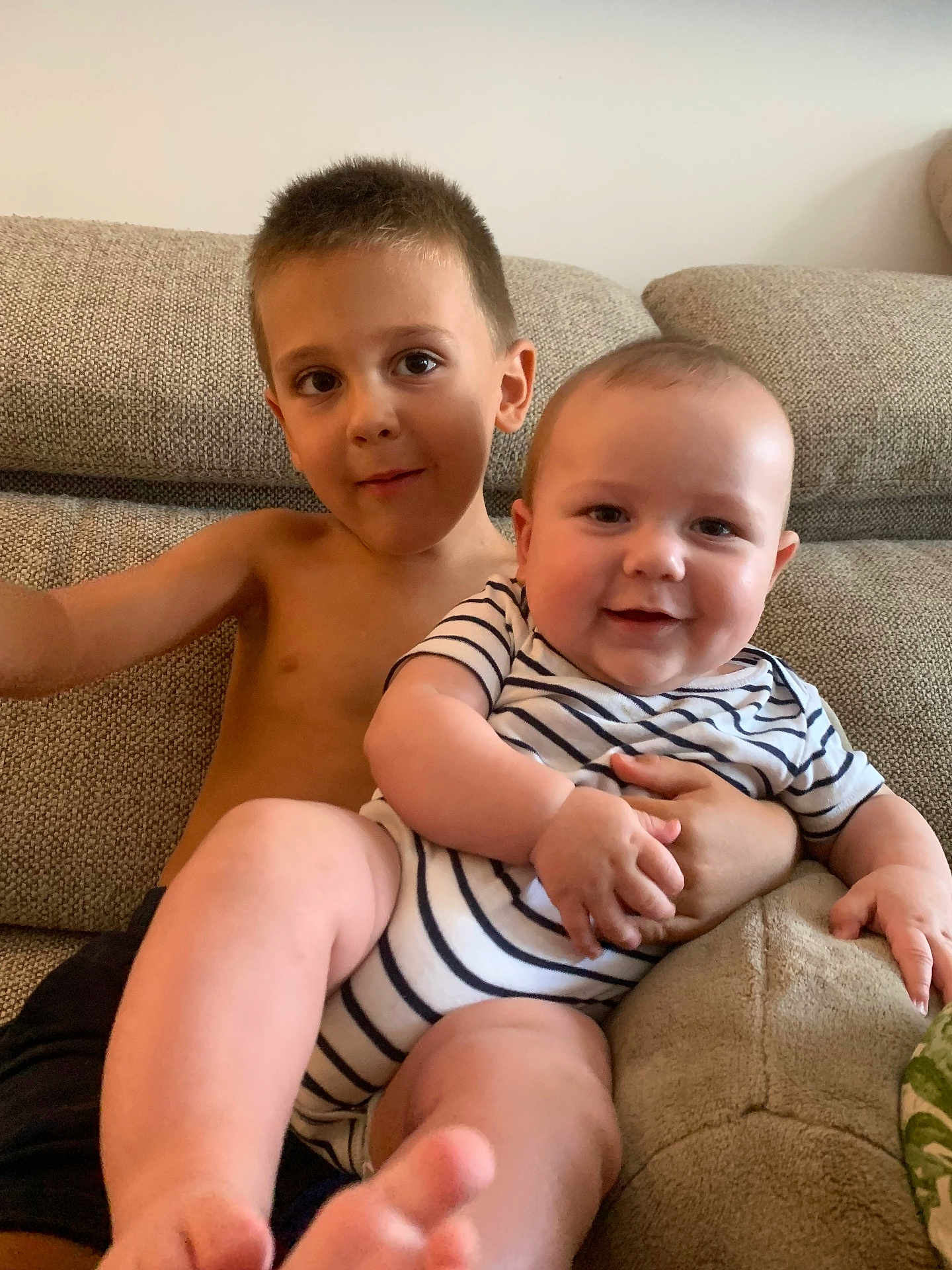 Gabriel a rejoint le concours — aidez-le/la à gagner de superbes lots ! baby, child, sibling, couch, striped_clothing, smile, happy, indoor, portrait, bare_chest, furniture, living_room, person, cute, young_child, infant, family, relaxing, skin, foot