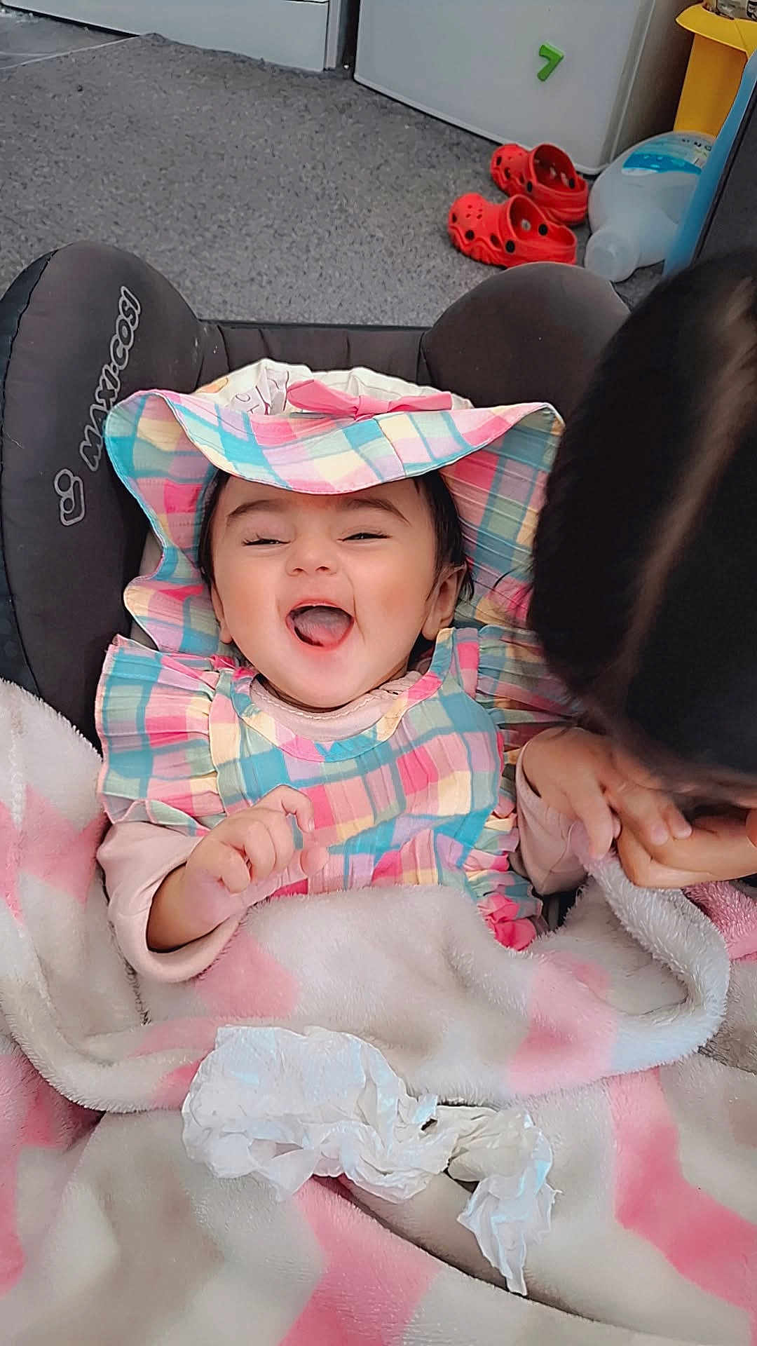 Inara joined the competition — help win amazing prizes! baby, child, smiling, hat, colorful_clothing, blanket, indoor, happy, person, face, infant, seated, fabric, playful, car_seat, tissue, pink, white, cute, joyful