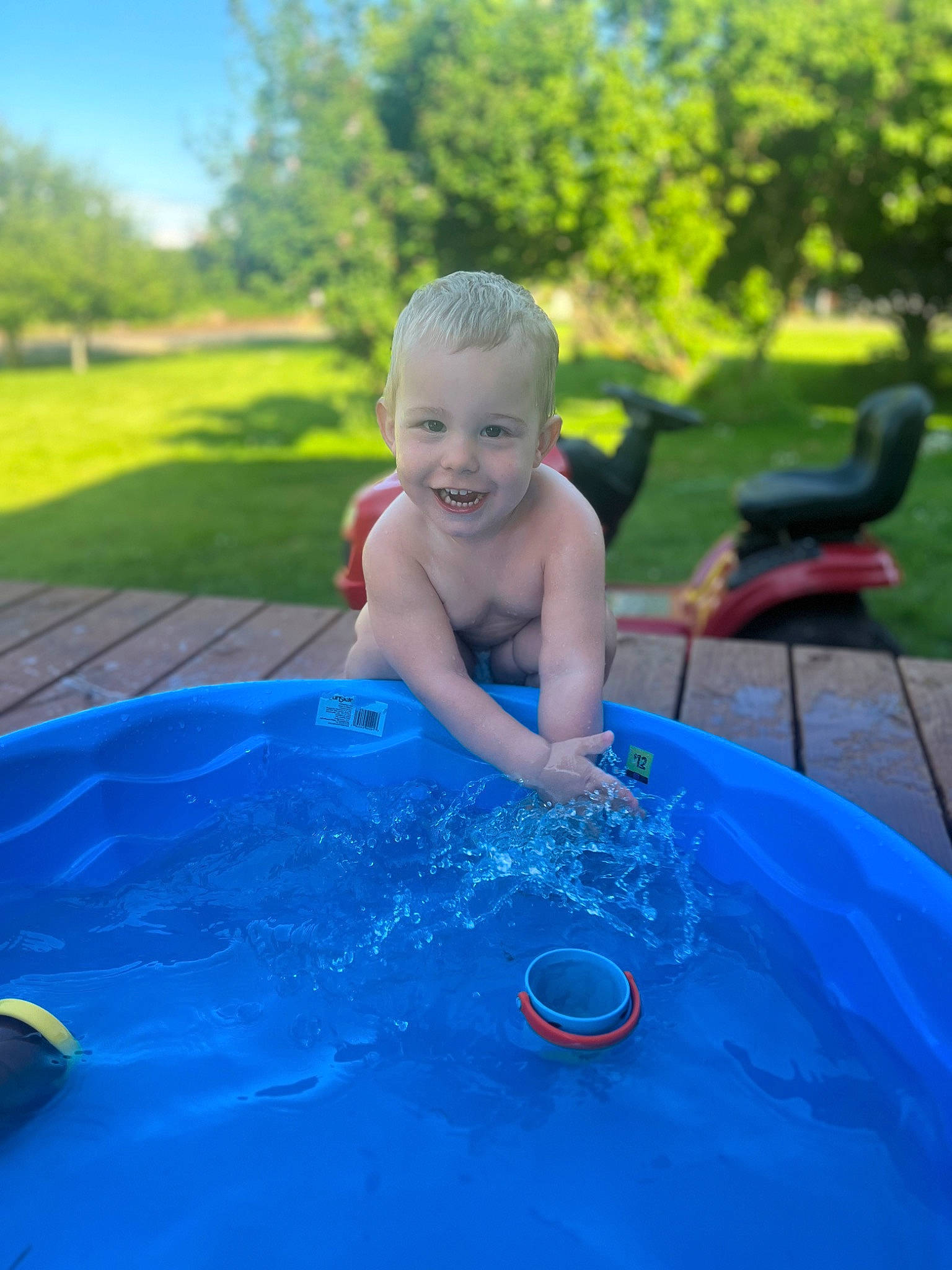 Jonah is registered to the contest to win money with this photo: azure, baby, bathing, child, electric_blue, fun, grass, happy, inflatable, joy, leisure, person, plant, recreation, sky, smile, summer, sunlight, toddler, tree