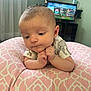 baby, infant, cushion, pink, pattern, hands, face, expression, indoor, room, television, screen, game, clothing, short_sleeve, curtain, window, furniture, person, child
