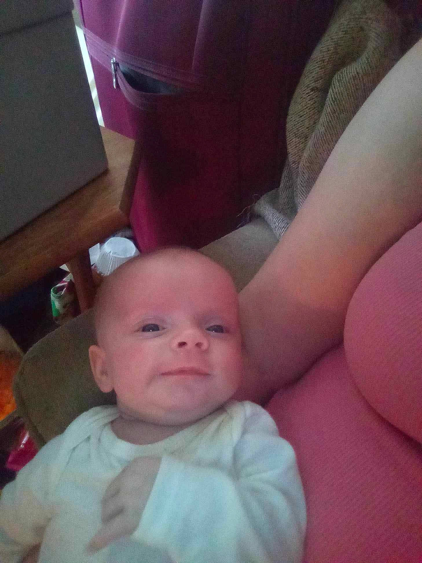 Novarose is registered to the contest to win money with this photo: arm, baby, cheek, comfort, elbow, eye, finger, gesture, hand, human_body, lap, leg, mouth, neck, person, pink, shipping_box, skin, thigh, toddler