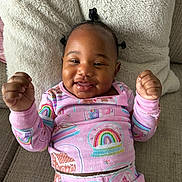 Amora is registered to the contest to win money with this photo: baby, child, smiling, pajamas, rainbow, couch, pillow, happy, infant, clothing, indoors, cute, portrait, person, furniture, cozy, relaxing, young, bedroom, home