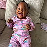Amora joined the competition — help win amazing prizes! baby, child, smile, pajamas, rainbow, gingerbread, couch, pillow, happy, infant, indoors, person, cute, cozy, patterned_clothing, relaxing, small_hands, hair_buns, playful, bright