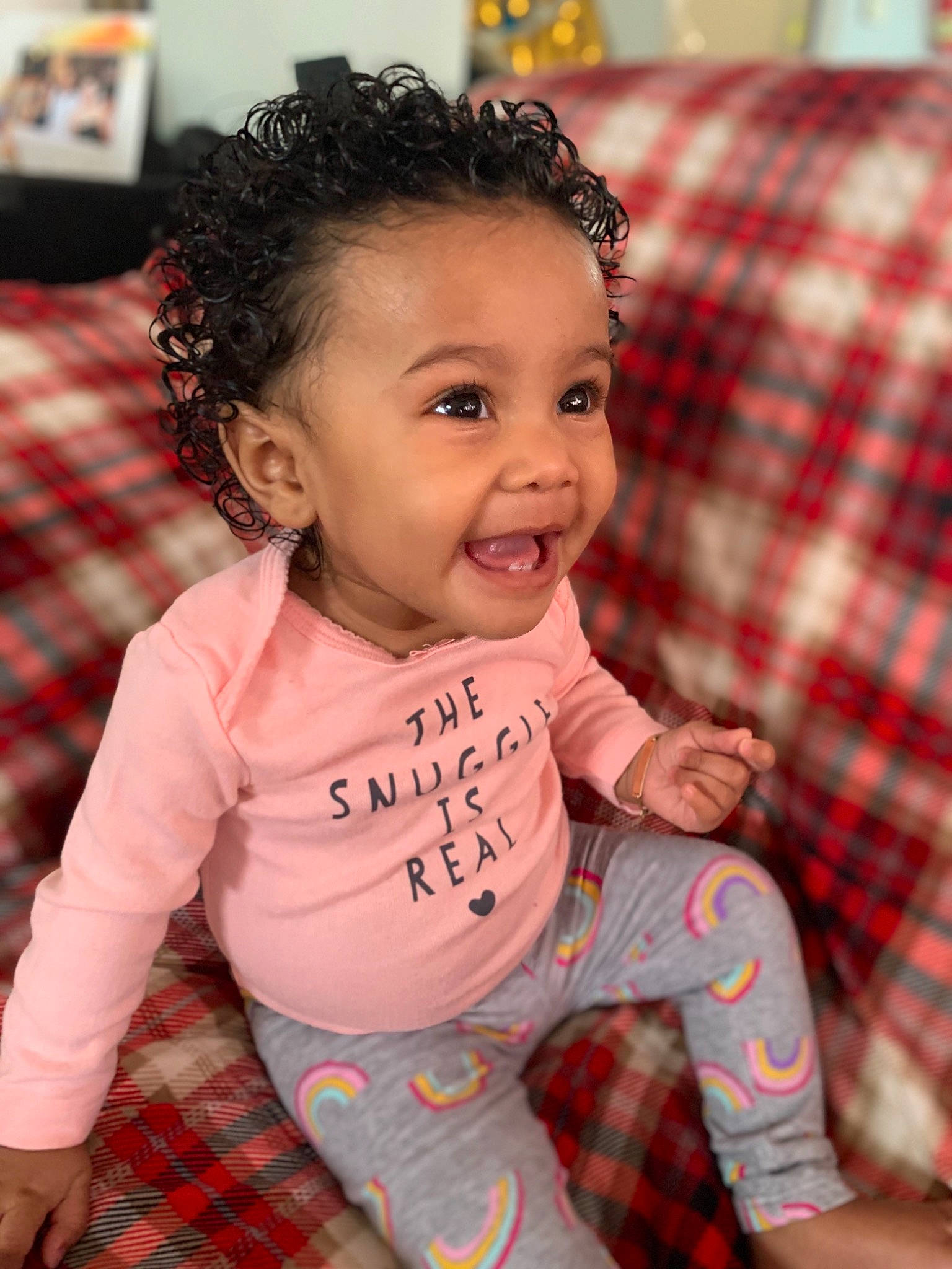 Riley is registered to the contest to win money with this photo: baby, cheek, child, christmas, face, joy, pattern, person, pink, plaid, skin, smile, toddler