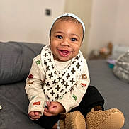 Eziah joined the competition — help win amazing prizes! apparel, baby, bib, boots, child, clothing, comfortable, cozy, cute, face, footwear, happy, home, indoor, infant, person, portrait, sitting, smiling, warm
