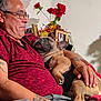 Manolo is registered to the contest to win money with this photo: casual, couch, dog, flowers, french_bulldog, glasses, gray_hair, hand, home, indoor, man, pet, picture_frame, portrait, red_shirt, relaxation, resting, sleeping, smile, tattoo