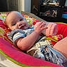 baby, bottle, child, cushion, seat, smile, indoor, person, clothing, furniture, face, hand, drool, cabinet, carpet, door, room, happy, infant, casual