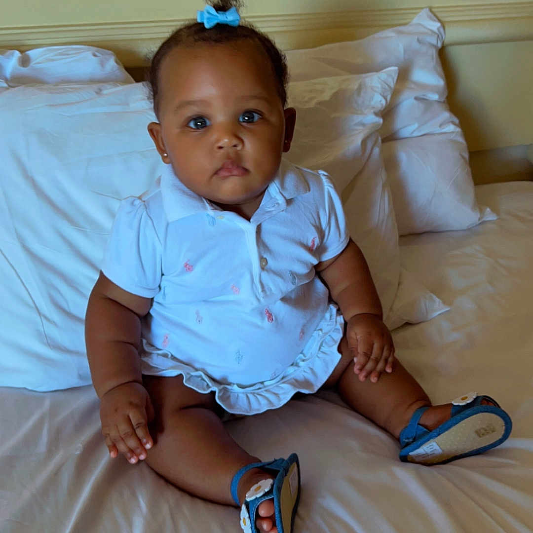 Sapphire is registered to the contest to win money with this photo: baby, bed, bodypart, clothing, couch, cushion, face, finger, footwear, furniture, hand, head, homedecor, person, photography, portrait, sandal, shoe, sitting, wood
