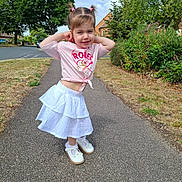 Violet joined the competition — help win amazing prizes! child, girl, pigtails, pink_shirt, white_skirt, shoes, sidewalk, trees, grass, suburban, residential_area, smiling, posing, daylight, outdoor, blue_sky, greenery, casual_clothing, happy, person