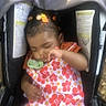 Lilly is registered to the contest to win money with this photo: toddler, child, sleeping, car_seat, pacifier, hair_clips, floral_dress, orange, pink, black_hair, infant, cute, baby, indoors, resting, seat_belt, young_child, peaceful, portrait, small_child